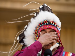 An emotional Sixties Scoop Indigenous Society of Alberta President Adam North Peigan, himself a Sixties Scoop survivor, wipes tears from his eyes as he responds to an apology by Premier Rachel Notley to survivors and families of the Sixties Scoop, on the steps of the Alberta Legislature in Edmonton Monday May 28, 2018. Photo by David Bloom