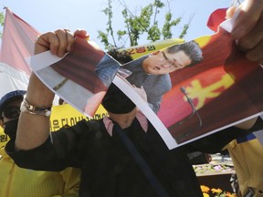 A North Korean defector tears a paper with a portrait of North Korean leader Kim Jong Un during a rally against the possible repatriation of North Korean restaurant workers to North Korea, in front of the Government Complex in Seoul, South Korea, Saturday, May 19, 2018. South Korea said on May 11, it will look closer into the circumstances surrounding the arrival of a dozen North Korean restaurant workers in 2016, after a television report suggested some of the women might have been brought to the South against their will.