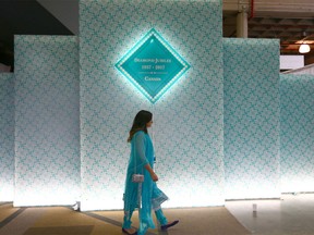 Sophia Virji walks in front of a backdrop at the BMO Centre in downtown Calgary after listening to the Aga Khan on Wednesday, May 9, 2018.