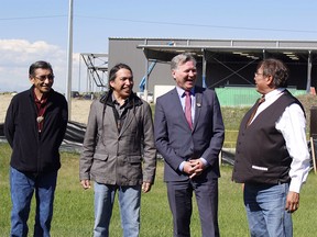 Tsuut'ina Nation Elder Gerald Meguinis, left, Coun. Ellery Starlight, Minister of Indigenous Relations Richard Feehan and Chief Lee Crowchild stand in front of the Seven Chiefs Sportsplex, which is under construction.