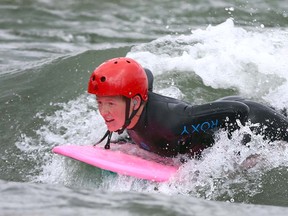 Shauna Diamond surf on the Bow River at the 10th Street bridge near downtown Calgary on Tuesday, May 1, 2018.