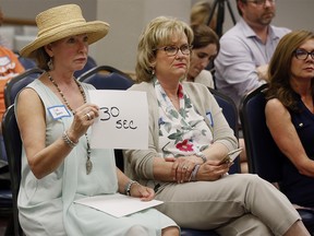 Vicki Toombs, left, handles the timing of speakers at a Democratic Congressional Forum in Edmond, Okla., Thursday, May 10, 2018. Toombs was watching the returns on election night 2016 when she received a text from her 22-year-old son Beau in Chicago. Beau, who is gay, was afraid that the new administration would end the Affordable Care Act and with it the insurance he and his friends used to pay for the drugs that protected them from HIV and AIDS. ìI just felt the bottom drop out of my world,î said Toombs, 61. She felt sheíd failed her son, as if Donald Trumpís election was somehow her fault. She had to do something. (AP Photo/Sue Ogrocki) ORG XMIT: NY864