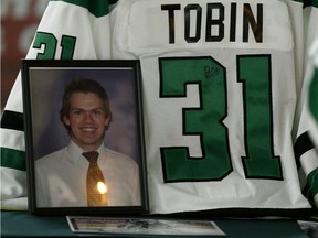 A candle is reflected on a photograph of Parker Tobin at a candlelight vigil held for the former Drayton Valley Thunder hockey player at the Omniplex in Drayton Valley, Alberta on Tuesday April 10, 2018. The hockey player for the SJHL Humboldt Broncos team was one of the players who died in a fatal bus crash when the team bus collided with a semi-trailer on a Saskatchewan highway. Parker Tobin was mistakenly believed to have survived the crash but it was later learned that he had been misidentified with teammate Xavier Labelle, who did survive.