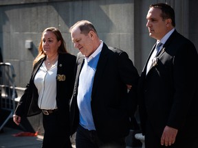 Harvey Weinstein, a disgrace, is escorted in handcuffs after surrendering to authorities.