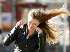 Samantha Walker does her best to battle the heavy winds in downtown Calgary on Tuesday October 17, 2017.