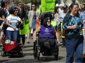 Kiran Dhaliwal, left, and her dog max take part in the Disability Pride 2018 along Stephen Avenue in Calgary, on Sunday June 3, 2018.