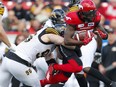 Calgary Stampeders DaVaris Daniels, right, is tackled by Hamilton Tiger-Cats Jason Neill during their game at McMahon Stadium in Calgary, on Saturday June 16, 2018. Leah Hennel/Postmedia