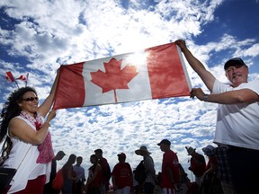 Minette Monette, left and Troy Rutherford show their Canadian pride during Canada's sesquicentennial celebrations at Fort Calgary in Calgary Saturday July 1, 2017. Leah Hennel/Postmedia