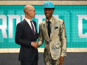 Shai Gilgeous-Alexander of Hamilton shakes hands with NBA commissioner Adam Silver after he was picked 11th by the Charlotte Hornets in the NBA draft. Moments later Gilgeous-Alexander was traded to the Los Angeles Clippers.