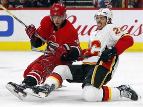 Carolina Hurricanes' Elias Lindholm collides with Calgary Flames' Travis Hamonic during the second period of an NHL hockey game, Sunday, Jan. 14, 2018, in Raleigh, N.C.