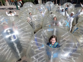 Student Lena Hrach and the Beakerhead crew launched their 2018 program and their September lineup by turning giant electrons and protons loose on Stephen Avenue which are so tiny you can't see them with the naked eye – until now in Calgary on Thursday June 7, 2018. Darren Makowichuk/Postmedia
