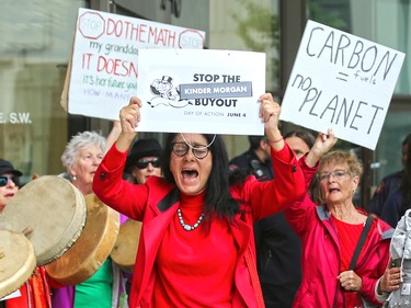 Wendy Walker (in red) leads anti Trans Mountain pipeline protester in a chant after they delivered a petition to Liberal MP Kent Hehr's office in downtown Calgary on Monday June 4, 2018. The petition was demanding a stop to the government's plan to buy Trans Mountain.