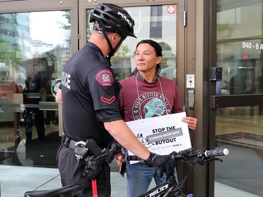 Police guard a doorway as anti Trans Mountain pipeline protesters delivered a petition to Liberal MP Kent Hehr's office in downtown Calgary on Monday June 4, 2018. The petition was demanding a stop to the government's plan to buy Trans Mountain.
