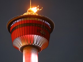 The cauldron on the top of the Calgary Tower burns to honour the gold medal performances by Mikael Kingsbury in moguls and the Canadian Figure Skating Team on Monday February 12, 2018. Darren Makowichuk/Postmedia