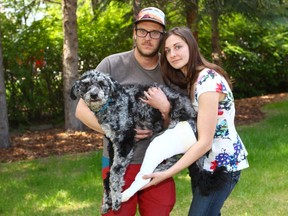 Rochelle and Jean-Michel Longval pose with their 15-month-old Aussiedoodle dog Geo in southwest Calgary on Sunday, June 17, 2018. Geo was injured on Monday when trapped in a snare in the Bebo Grove area Fish Creek Park.