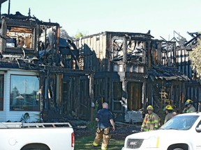 Firefighters on the scene Wednesday morning after fire destroyed three homes on Woodbrook Way S.W. on Tuesday, June 20, 2018.