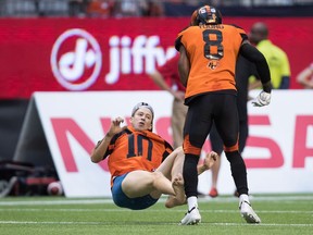 B.C. Lions' Marcell Young (8) knocks down a spectator that ran onto the field of play during the first half of a CFL football game against the Montreal Alouettes in Vancouver, on Saturday June 16, 2018.