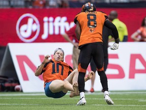 B.C. Lions Marcell Young knocks down a spectator who ran onto the field during the first half of a CFL football game against the Montreal Alouettes in Vancouver, on June 16, 2018.