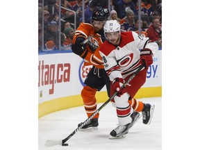 Carolina Hurricanes' Elias Lindholm (28) is chased by Edmonton Oilers' Adam Larsson (6) during first period NHL action in Edmonton, Alta., on Tuesday, October 17, 2017.