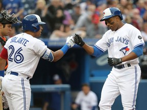 Curtis Granderson, right, of theToronto Blue Jays is congratulated by teammate Yangervis Solarte after hitting a homer during MLB action Thursday night at Rogers Centre. The Jays spotted the Baltimore Orioles a 4-1 lead before rallying to win 5-4 in 10 innings.