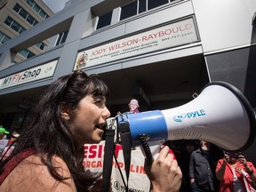 A woman uses a bullhorn as protesters opposed to the Kinder Morgan Trans Mountain pipeline extension demonstrate outside Justice Minister Jody Wilson-Raybould's constituency office, in Vancouver, on Monday June 4, 2018.