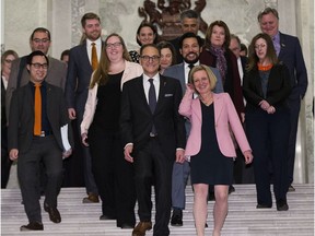 Premier Rachel Notley and members of her government walk down steps in the legislature.