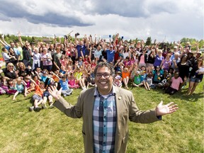 Mayor Naheed Nenshi mugs for a group shot with a throng of neighbours during a community get-together in the West Grove community on Neighbour Day in 2015. Communities across the city celebrate Neighbour Day this year on Saturday, June 16.