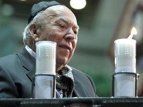 Sam Switzer lights the Menorah candles during a Hanukkah ceremony at Calgary city hall on Dec. 11, 2012.