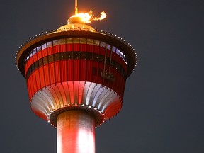 The cauldron atop the Calgary Tower burns to honour gold medal performances by Mikael Kingsbury in moguls and the Canadian Figure Skating Team on Monday Feb. 12, 2018.