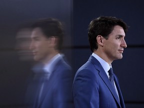 Prime Minister Justin Trudeau is reflected in a TV screen as he speaks at a press conference in Ottawa on June 20, 2018.