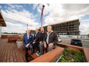 Tony Trutina, Peter Trutina, Oliver Trutina, and George Trutina of Truman with the first phase of residential development at West District under construction behind them.