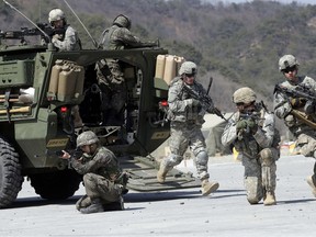 In this March 25, 2015, file photo, U.S. Army soldiers stationed in South Korea pour out of a Canadian-made Stryker armoured personnel carrier.