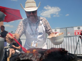 Ian Newman cooks up some BBQ ribs on the grill during the cook-off in the cowboys tent at the calgary Stampede in Calgary, on Thursday July 12, 2018. Leah Hennel/Postmedia