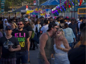 A young couple share a moment on the Calgary Stampede midway on July 13, 2018.
