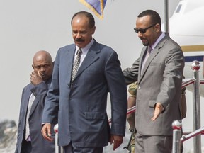 Eritrean President Isaias Afwerki, foreground left is welcomed by Ethiopia's Prime Minister Abiy Ahmed upon his arrival at Addis Ababa International Airport, Ethiopia, Saturday, July 14, 2018. To dancing and cheers, Eritrea's longtime president arrived in Ethiopia for his first visit in 22 years on Saturday amid a dramatic diplomatic thaw between the once-bitter rivals.