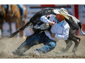 Cochrane bulldogger Straws Milan planted his steer in a time of 3.8 seconds on Day 8 of the steer-wrestling event at the 2018 Calgary Stampede on Friday, July 13, 2018. Al Charest/Postmedia