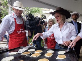Alberta Premier Rachel Notley, centre, cooks pancakes at the Premier's annual Stampede breakfast in 2017. This year's Premier Stampede Breakfast goes on Monday, July 9.