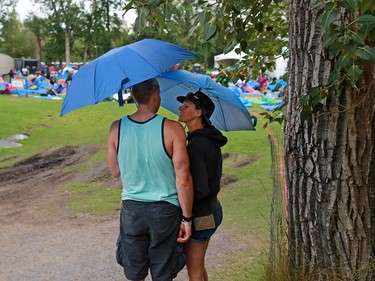Fans shelter as a thunderstorm passes over the Calgary Folk Festival on opening night, Thursday July 26, 2018.
