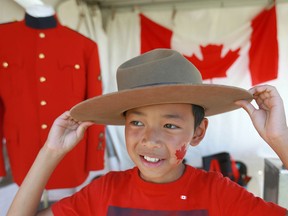 Evan Huang, 11, tries on a Mountie hat during Canada Day celebrations at Fort Calgary near downtown Calgary on Sunday, July 1, 2018. (Jim Wells/Postmedia)