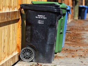A black cart is shown with compost and recycle bins in an alley in the Elboya community in southwest Calgary Wednesday, April 18, 2018.