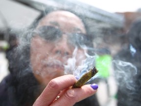 Cynthia Wong smokes cannabis during '420 day' in downtown Calgary at Olympic Plaza on Friday, April 20, 2018. She has been smoking for 19 years and has a medical card to for pain control and insomnia. Jim Wells/Postmedia