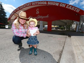 Jennifer Booth poses with her 18 month old toddler Zoey at the entrance to Stampede Park in Calgary on Friday, June 29, 2018. Jim Wells/Postmedia