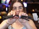 Kayla Taylor, a waitress at Jamesons Irish Pub on 17th Avenue SW, opens a handful of straws on July 14, 2018. The pub no longer uses straws, although concessions are made for people with disabilities.