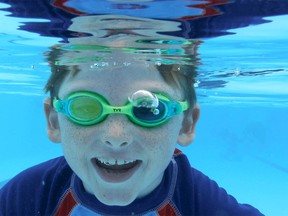 Ryan Gurden, 8 yrs has some summer fun underwater as he poses at Stanley Park Pool in southwest Calgary on Thursday, July 19, 2018. Jim Wells/Postmedia