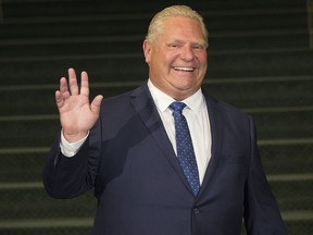 Ontario Premier Doug Ford waves to the media at Queens Park in Toronto on July 5, 2018.