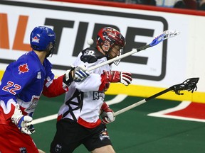 Rock Phil Caputo (L) knocks the ball loose from Roughnecks Garrett McIntosh during National Lacrosse League action between the Toronto Rock and the Calgary Roughnecks in Calgary on Saturday, March 24, 2018. Jim Wells/Postmedia