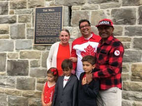 Mayor Naheed Nenshi, along with Linda and Mike Shaikh and their grandchildren Clara, Matthew and Jonathan, unveil a plaque to mark the restoration of a retaining wall built in the 1890s around their Mount Royal home. (Sammy Hudes/Postmedia)