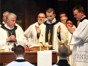 Rev. Derek Remus, centre, takes part in the eucharistic prayer with Calgary Bishop William McGrattan, left, during the Ordination Mass. Photo: Ryan Factura/Calgary Diocese