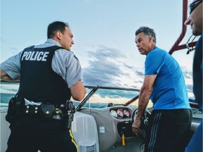 Keith Crone driving his boat with the RCMP officer that first arrived on scene to help people whose boat capsized in the icy waters of Ghost Lake Reservoir Saturday night. (Supplied)