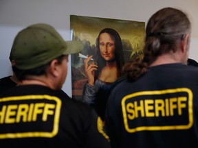 A group of undercover Los Angeles County sheriff's deputies gather inside an illegal marijuana dispensary during a raid in Compton, Calif.
